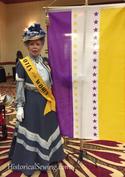 Costume College 2019 - Carolyn Runnels in her Edwardian Votes for Women ensemble and flag