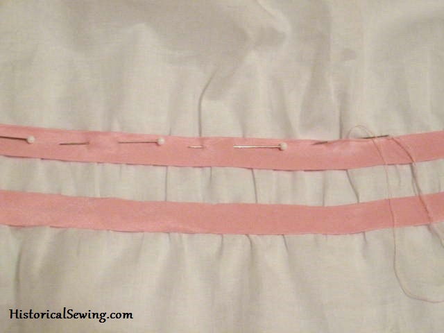 Stitching pink bias bands by hand